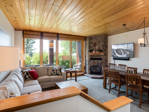 Unwind in your cozy mountain retreat with a crackling fireplace, plush seating, and natural wood accents that create a warm, inviting atmosphere for your alpine getaway.