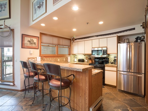 Your fully equipped kitchen awaits with granite counters, stainless appliances, and a cozy breakfast bar perfect for morning coffee or evening conversations with loved ones.