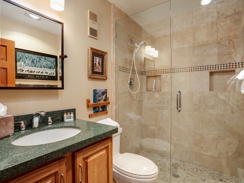 This beautifully tiled bathroom features everything you need to refresh after a day of exploring. A spacious walk-in shower, contemporary fixtures, and warm wood accents create a welcoming retreat.