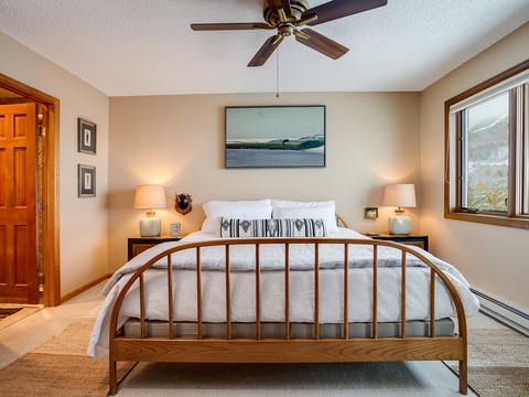 Wake up to mountain views in your serene bedroom, where soft lighting, a cozy ceiling fan, and crisp linens create the perfect retreat after a day of adventure.