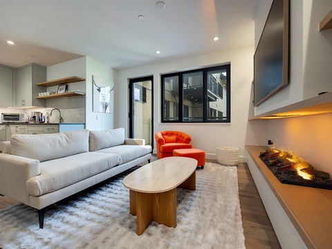 Sink into plush seating by the glowing fireplace, where modern design meets mountain-chic comfort. Your open-concept living space seamlessly blends relaxation with a fully-equipped kitchen for effortless entertaining.