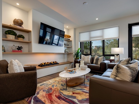 Settle into this sunlit living room, where plush leather sofas and a cozy fireplace create your perfect retreat after a day of adventure.