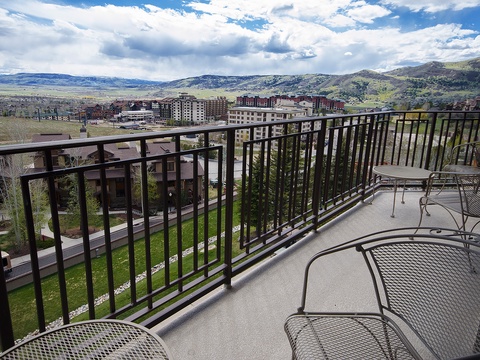 Mountain vistas meet modern comfort on this spacious balcony, where you can unwind in outdoor seating and take in sweeping views of the surrounding area.