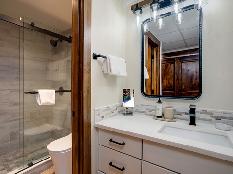 Unwind in your beautifully designed bathroom with modern fixtures, soft towels, and a spacious walk-in shower—your personal retreat after a day exploring.