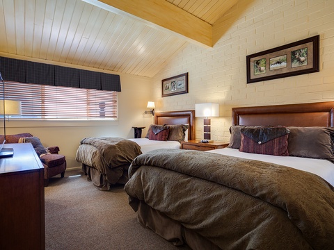 Sink into plush beds under vaulted wood ceilings in your private retreat. Cozy textures and warm lighting create the perfect sanctuary for restful mountain nights.