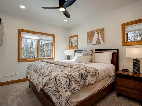 Drift off in this serene bedroom with plush bedding and peaceful forest views through your windows. Your private sanctuary awaits with modern comfort and natural light.