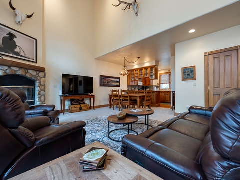 Sink into plush leather seating in your spacious living area, where vaulted ceilings and rustic charm create the perfect mountain retreat for unwinding after a day of adventure.