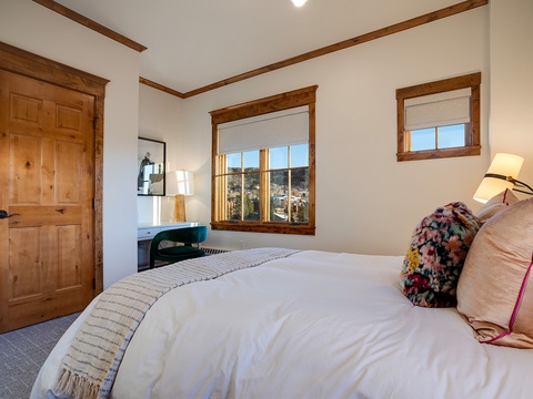 Sink into plush bedding and wake to mountain views framed by rustic wood accents. Your cozy retreat features warm touches and natural light for ultimate relaxation.