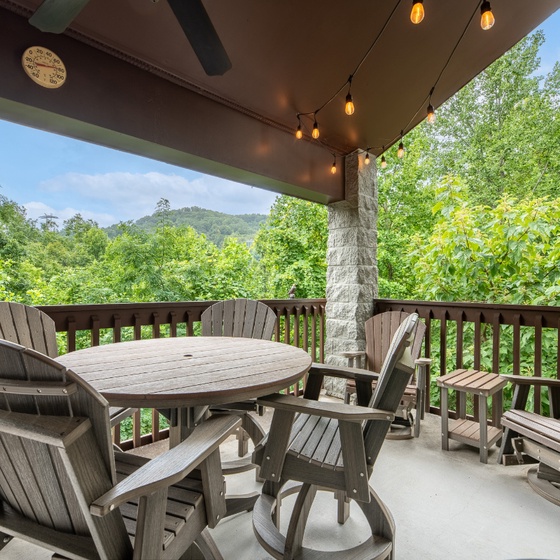 Your private covered deck offers stunning mountain views framed by lush forest—perfect for morning coffee or evening unwinding in those comfy chairs.
