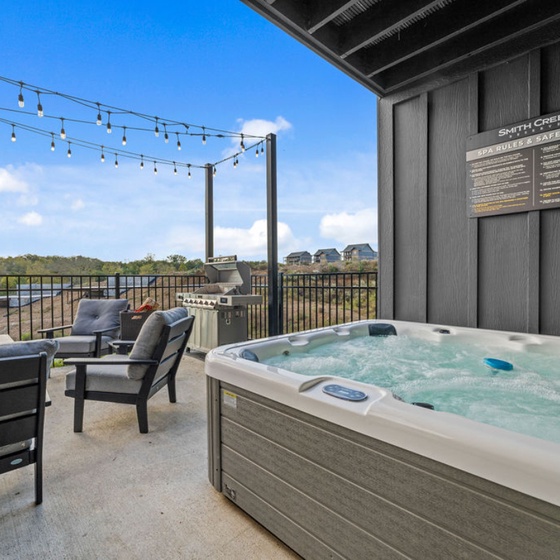 Unwind in your bubbling hot tub on this scenic balcony, where twinkling string lights create perfect ambiance for evening soaks.