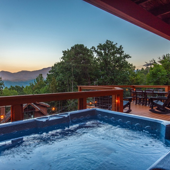 Soak in your private hot tub as the sun sets behind mountain ridges—a perfect evening watching daylight fade into dusk from your covered terrace.