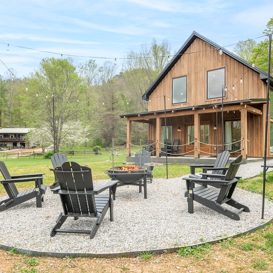 Gather around the crackling fire pit where marshmallows toast and stories flow beneath twinkling string lights on this peaceful gravel patio.