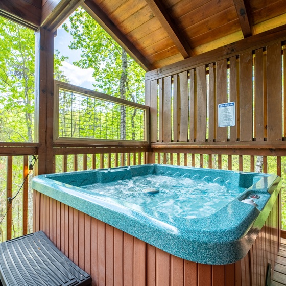 Soak your worries away in your private hot tub, surrounded by lush forest views from this peaceful covered deck.