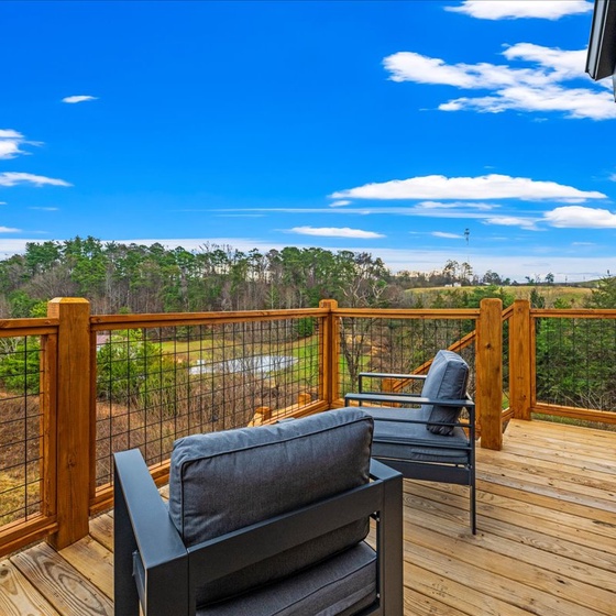 Unwind on your private deck with plush seating while taking in breathtaking countryside views stretching across rolling hills and forests under endless blue skies.