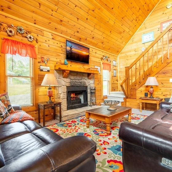 Settle into plush leather seating as the fireplace crackles beside you, warming the rich wood-paneled space where your mountain retreat truly begins.