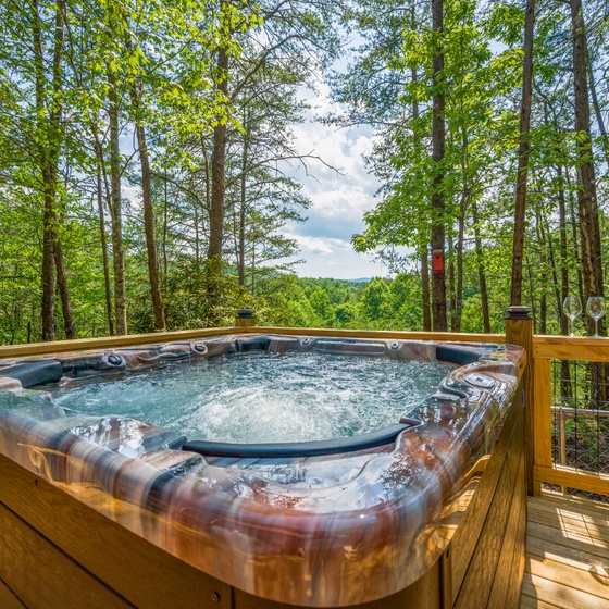 Soak in bubbling bliss while surrounded by towering trees and peaceful forest views from your private deck retreat.