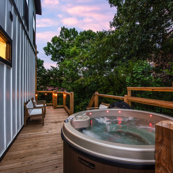Unwind in your private hot tub on the deck, surrounded by lush greenery and soft twilight. The perfect retreat after a day of adventure.