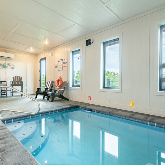 Take a refreshing dip in your own private indoor pool, complete with poolside seating where you can relax and unwind while enjoying views of the surrounding greenery through large windows.
