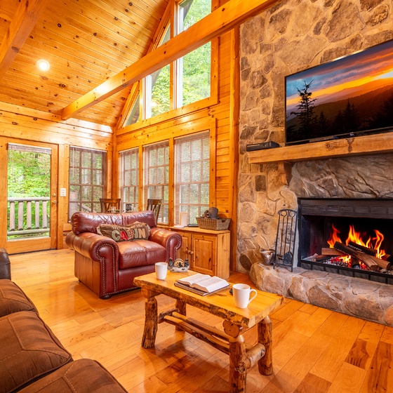 Cozy up in this stunning living room with vaulted wood ceilings, a crackling stone fireplace, and plush seating where you can unwind after a day of mountain adventures.