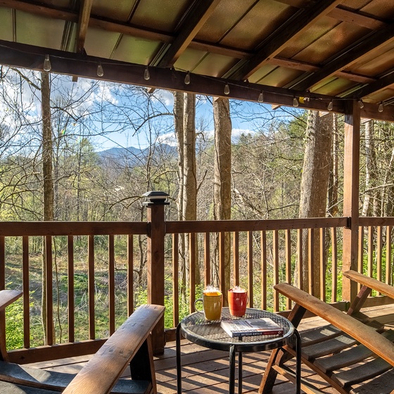 Sip your morning coffee on this peaceful covered deck, surrounded by towering trees and mountain views.