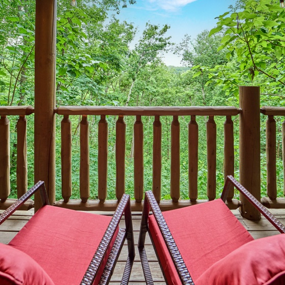 Settle into your private deck surrounded by lush forest canopy, where red-cushioned loungers invite you to breathe in the fresh mountain air and reconnect with nature.