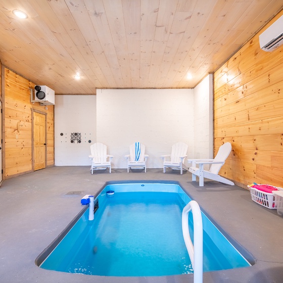 Dive into your private indoor pool surrounded by warm wood walls and comfortable seating—perfect for year-round relaxation.