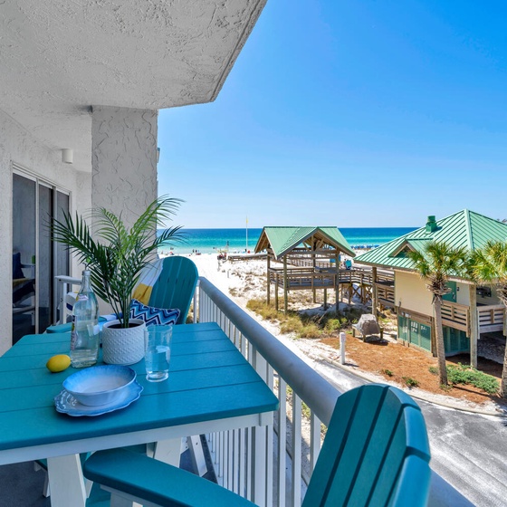 Sip your morning coffee at this charming balcony table while gazing at pristine white sands and turquoise waters just steps away.