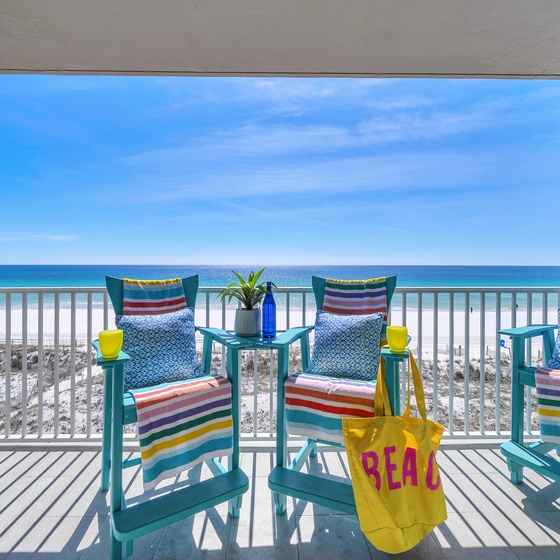 Unwind on your private beachfront balcony with colorful seating and stunning ocean views stretching to the horizon.