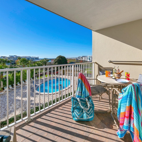Start your morning with coffee on your private balcony, overlooking the sparkling pool and vibrant resort grounds below.
