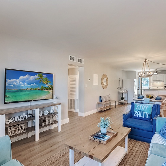 Welcome to Venus 108 - Stay Salty! Relax in this bright, coastal-themed living space with comfortable seating and open kitchen flow for memorable vacation moments.