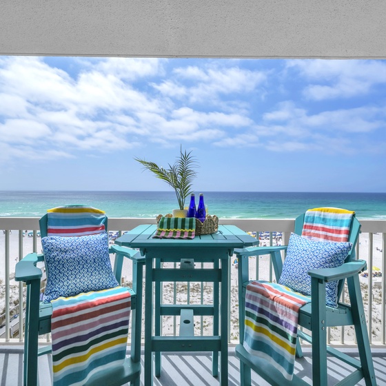 Sip your morning coffee on your private beachfront balcony, where colorful striped cushions and tropical touches frame endless turquoise waters.