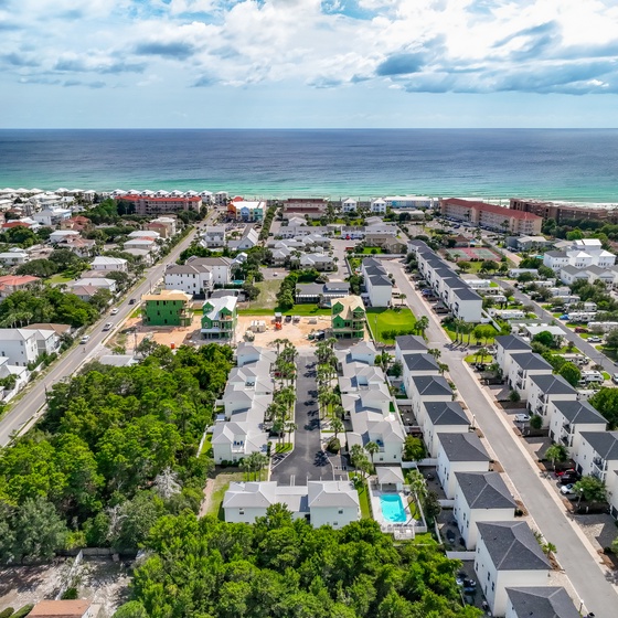 Aerial view of a residential neighborhood with modern homes and community amenities just steps from pristine beach access.