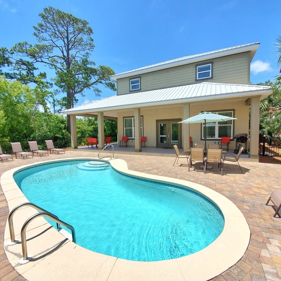 Back of Destin Sun with a Wrap Around Style Covered Back Porch! Lots of Seating! Large Private Saltwater Pool! Lounge Chairs! 2 Outdoor Dining Areas! Grill! A Backyard for the Whole Family to Enjoy!