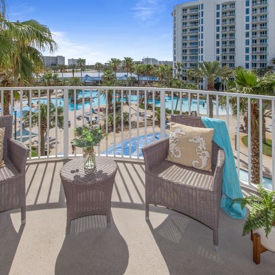 Your private balcony offers stunning views of the sparkling pool area and tropical palms below, where you can sip morning coffee in comfort.