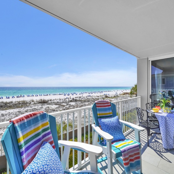 Your beachfront balcony offers stunning sea views with colorful seating overlooking pristine white sands and crystal-clear waters.