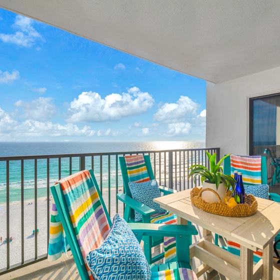 Soak up stunning gulf views from your private balcony, where colorful chairs await lazy afternoons and the endless water stretches before you.