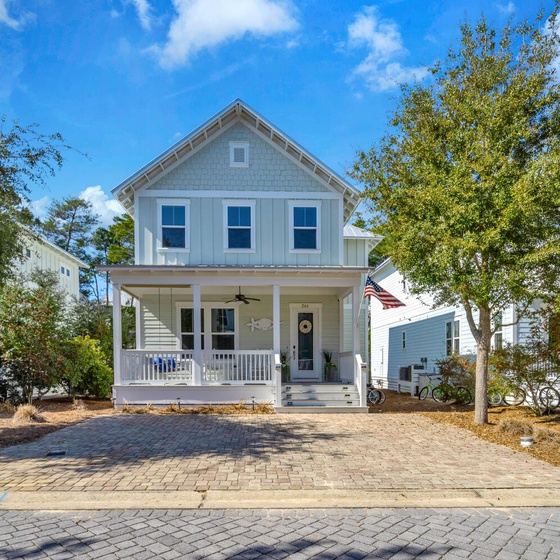 Welcome to Rolling Blue Tides, a charming coastal cottage with classic front porch and mature landscaping in peaceful neighborhood setting.