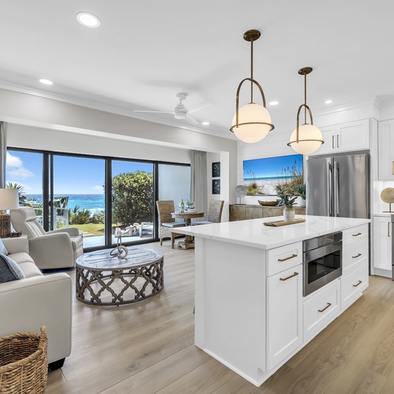 Wake up to stunning ocean views from your modern kitchen and living space, where warm wood floors and coastal breezes create the perfect beachside retreat.