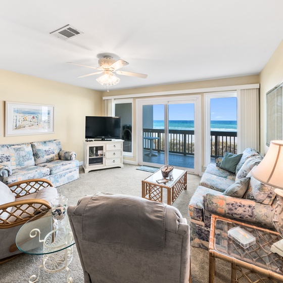 Relax in your spacious oceanfront living room where soft coastal furnishings and panoramic sea views create the perfect beach getaway retreat.