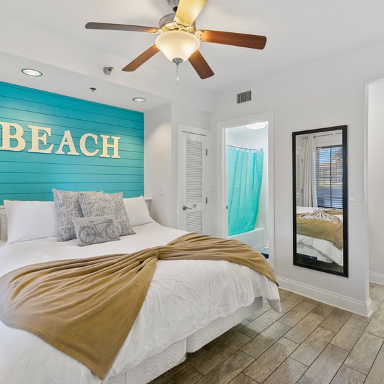 Your coastal bedroom retreat features a stunning turquoise accent wall and crisp white bedding, creating the perfect beachy vibe for restful nights.