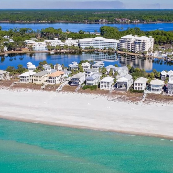 Stunning beachfront community with pristine white sand beach and turquoise waters stretching along the coastline.