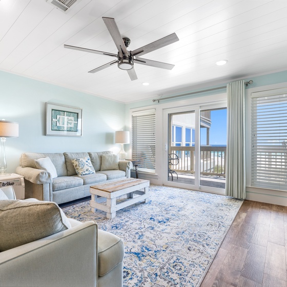 Unwind in your bright, coastal-inspired living room with plush seating and balcony access to enjoy refreshing breezes.