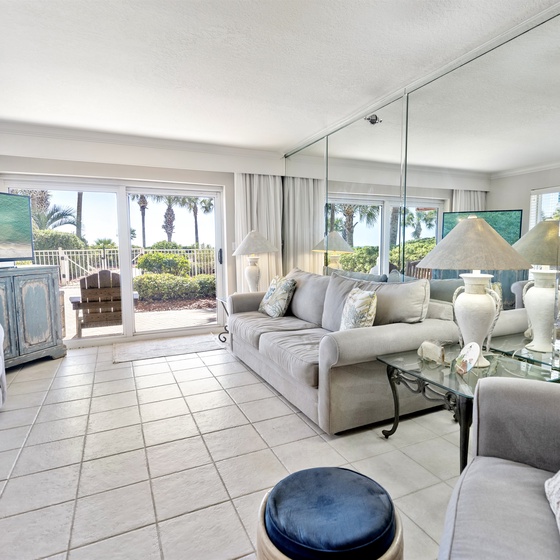 Relax in your elegant living room where coastal blues meet sophisticated comfort, with stunning views creating the perfect vacation backdrop.