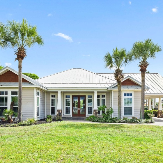 Beautiful coastal home with tropical palm trees and manicured landscaping welcomes guests to their Florida getaway destination.