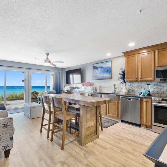 Your open-concept kitchen flows into a cozy living area where stunning ocean views create the perfect backdrop for cooking and relaxing together.