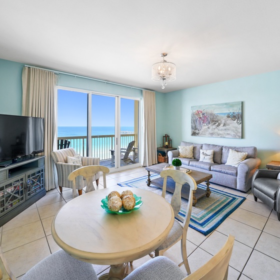 Relax in your bright living space with stunning ocean views through floor-to-ceiling windows. Your comfortable seating awaits for peaceful evenings.