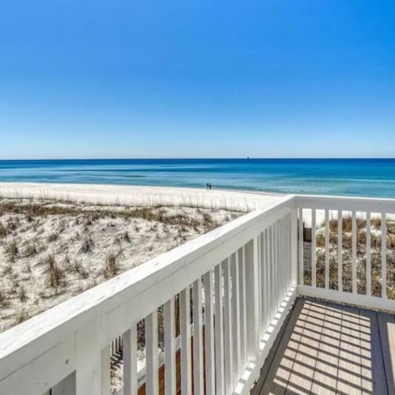 Stunning beachfront deck overlooking pristine white sand and turquoise waters, perfect for morning coffee or evening relaxation.
