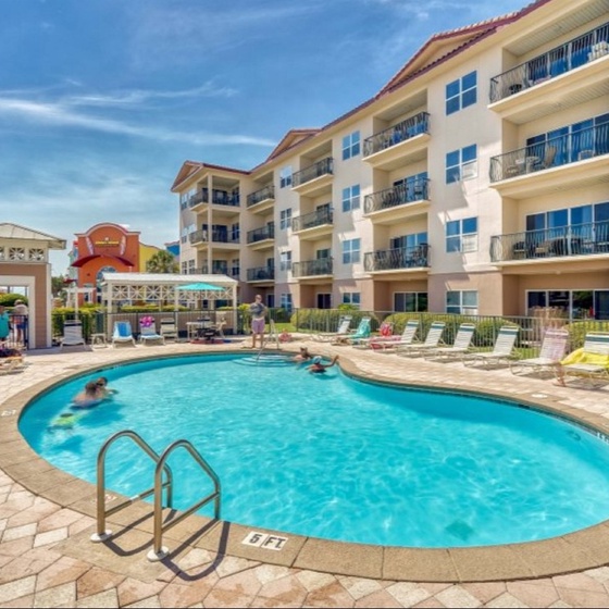 Dive into your perfect getaway at this sparkling pool oasis, surrounded by comfortable lounge chairs and vibrant resort atmosphere.