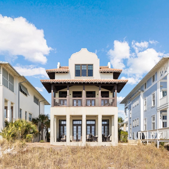 Stunning beachfront homes create a charming coastal neighborhood with distinctive architecture and natural dune landscaping.