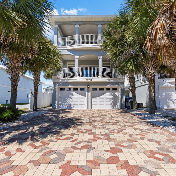 Coastal paradise awaits at this stunning beachside property, featuring elegant architecture framed by swaying palms and tropical landscaping.